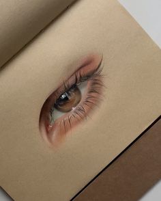 an eye is shown in the middle of a piece of paper with a pencil drawing on it