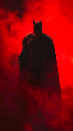 the dark knight stands in front of a red background