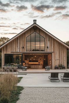 two lawn chairs sitting in front of a barn