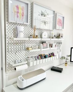 a white desk topped with lots of shelves filled with books and office supplies next to a computer