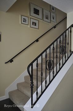 a staircase with pictures on the wall above it