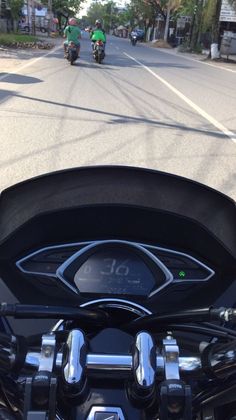 a motorcycle driving down a street next to tall buildings