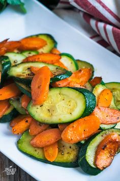 a white plate topped with cucumbers and carrots