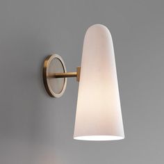 a wall light that is on the side of a wall with a white glass shade