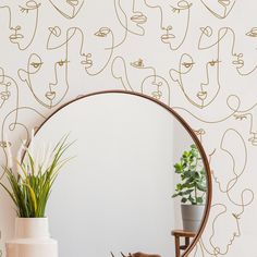 a mirror sitting on top of a table next to a plant and potted plant