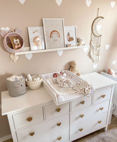 a baby's room with pink walls and hearts on the wall