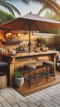 an outdoor bar with stools and umbrella