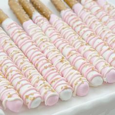 there are many pink and white desserts on the table with gold sprinkles