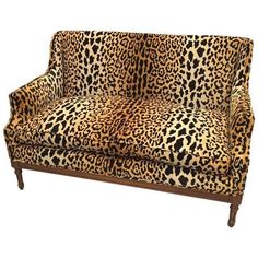 a leopard print couch sitting on top of a wooden frame