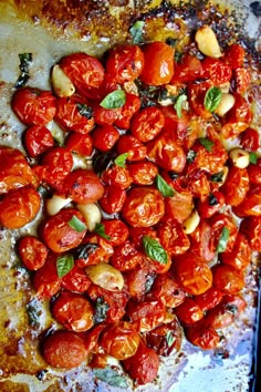 roasted tomatoes and basil on a baking sheet