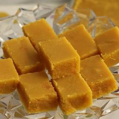 cubes of yellow cake sitting on top of a glass plate covered in ice crystals