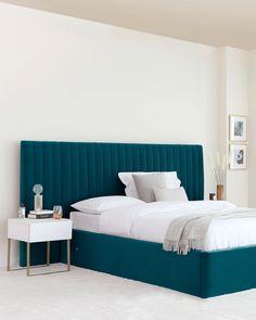 a bed with a blue headboard and white sheets