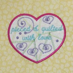 embroidered heart with words on it sitting on top of a yellow wallpapered background