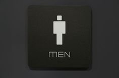 a black and white bathroom sign with the word men written in silver letters on it