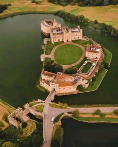 an aerial view of a castle in the middle of a lake and surrounded by land