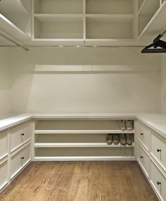 an empty walk in closet with wooden floors