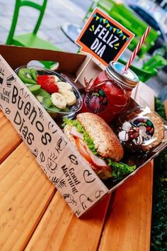 a box filled with lots of food sitting on top of a wooden table