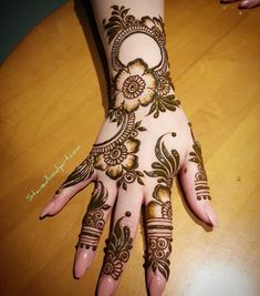 a henna on someone's hand that is sitting on a table