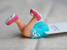 a small toy doll laying on top of a bed