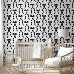 a baby's room with black and white wallpaper that has bows on it