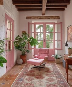 a living room with pink walls and an area rug that has a chair on it