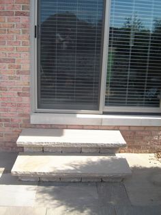 a stone bench sitting in front of a window