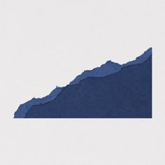 a blue piece of paper sitting on top of a white surface with a mountain in the background