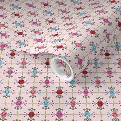 a pink wallpaper with multicolored flowers on it and a white roll in front