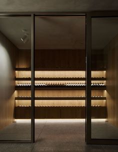 an empty room with wooden shelves and glass doors