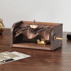 a wooden clock sitting on top of a table next to a mouse pad and pen