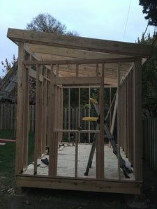 a small wooden structure sitting in the middle of a yard