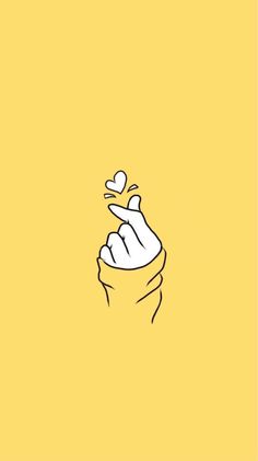 a yellow background with a hand holding a white object