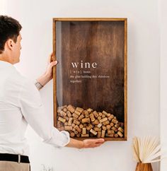 a man holding a wine corks in front of a sign