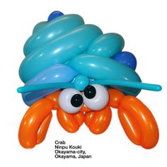 an orange and blue octopus balloon with big eyes on it's head is floating in the air