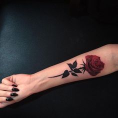 a woman's arm with a rose tattoo on it