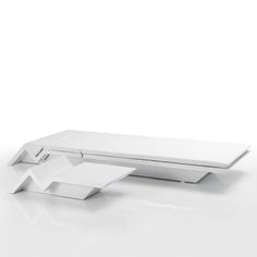 a white table sitting on top of a white floor