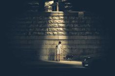 a person standing in front of a wall with a dog