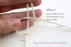 a hand holding a white string with instructions on how to tie the cord in one hand