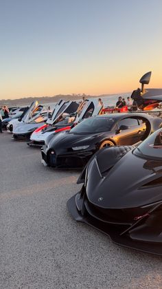 a row of cars parked next to each other on top of a parking lot near the ocean