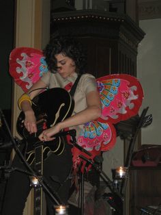 a woman playing an electric guitar on stage