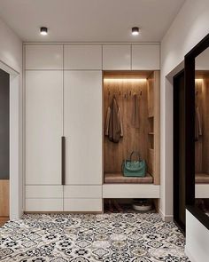 a walk in closet with white cabinets and black and white patterned flooring on the walls