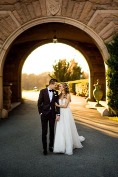 a bride and groom standing in front of an archway at the end of their wedding day