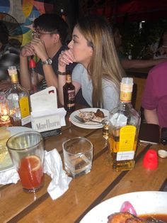 people sitting at a table with food and drinks