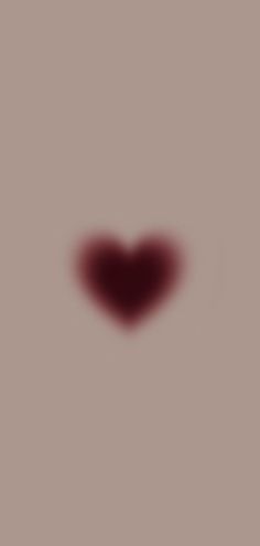 a blurry image of a red heart on a gray background with the shadow of a person's head