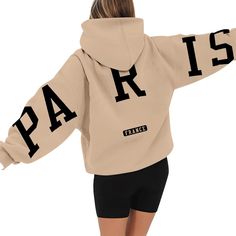 the back of a woman's hoodie that says paris on it and has black letters