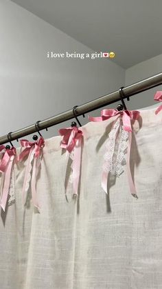 pink ribbon tied to the curtain with i love being a girl written on it