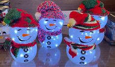 three lighted snowmen with hats and scarves