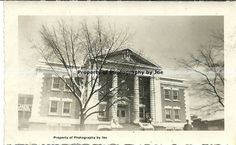 an old black and white photo of the front of a building with columns on it