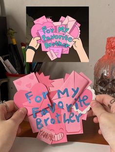 two hands holding up pink and blue paper cutouts that say for my favorite brother