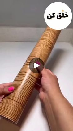 a person is holding a roll of wood in their hand and touching it with the other hand